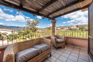 a balcony with wicker furniture and a view at villa Isabel 2 in Villasimius