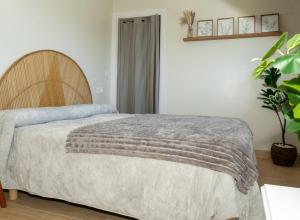 a bedroom with a bed with a wooden headboard at Casa Muxía Mar y montaña in Muxia