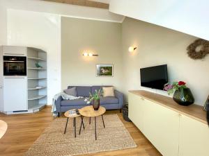 a living room with a blue couch and a tv at Ferienwohnung Fernblick in Königsberg in Bayern