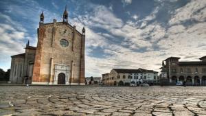 an old building with a clock tower in a city at The Comfort Apartment in Montagnana