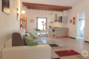 a living room with a white couch and a kitchen at The Comfort Apartment in Montagnana