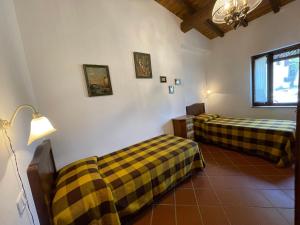 a room with two beds and a lamp in it at I Profumi Dell'Orto - Campagnatico in Campagnatico +70 photos