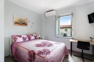 a bedroom with a pink bed and a desk and a window at Al Vecchio Pozzo in Brebbia