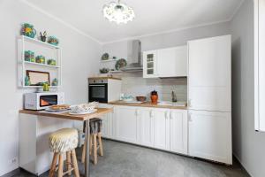 a kitchen with white cabinets and a wooden table at Al Vecchio Pozzo in Brebbia