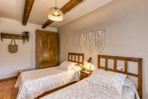 a bedroom with two beds and a chandelier at Can Planas 1 in Fonolleras +20 photos
