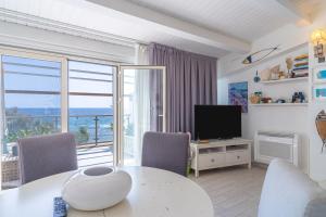 a living room with a table and a television at Elvi Suite Vista Mare Marzamemi in Marzamemi