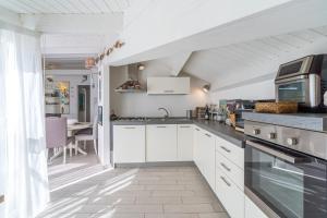 a kitchen with white cabinets and a counter top at Elvi Suite Vista Mare Marzamemi in Marzamemi