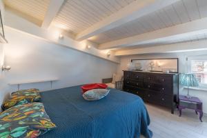 a bedroom with a blue bed and a dresser at Elvi Suite Vista Mare Marzamemi in Marzamemi