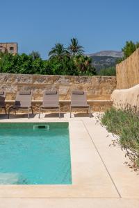 a swimming pool with lounge chairs next to a wall at Cas Suis 7 in Campanet