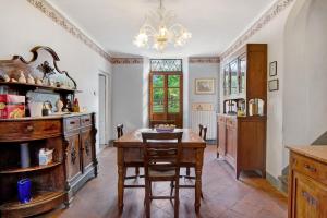 a dining room with a table and a chandelier at Tuscany Charme Coselli Restored in Capannori