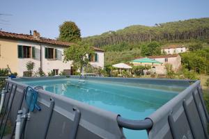 a swimming pool in front of a house at Tuscany Charme Coselli Restored in Capannori