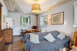 a living room with a blue couch and a table at Tuscany Charme Coselli Restored in Capannori