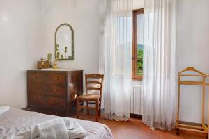 a bedroom with a dresser and a chair and a window at Tuscany Charme Coselli Restored in Capannori +37 photos