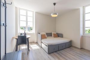 ein Schlafzimmer mit Bett, Tisch und Fenstern in der Unterkunft Chatus in Ruoms