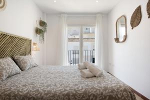 a bedroom with a large bed with a large window at Casa Noria in Vejer de la Frontera +21 photos