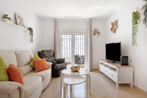 a living room with a couch and a tv at Casa Noria in Vejer de la Frontera