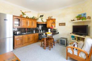 a kitchen with wooden cabinets and a table and a refrigerator at El Golfo Lanzarote in El Golfo +17 photos