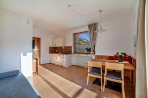 a kitchen and living room with a table and chairs at Langstein Wohnung Rose in Coldrano
