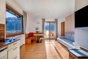 a kitchen and living room with a couch and a table at Langstein Wohnung Rose in Coldrano