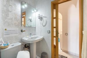 a bathroom with a sink and a toilet and a mirror at El Golfo Lanzarote in El Golfo