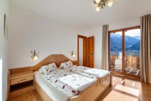 a bedroom with a bed and a large window at Langstein Wohnung Rose in Coldrano
