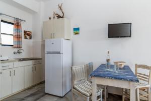 a kitchen with a table and a white refrigerator at Perasma Studio 1 in Kipri