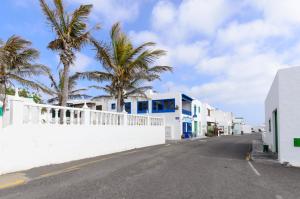 a street with palm trees and a white fence at El Golfo Lanzarote in El Golfo