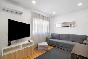 a living room with a couch and a flat screen tv at Telmus Villa Rc in Monte Gordo