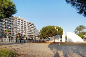 a large building with a playground and a tree at Telmus Villa Rc in Monte Gordo