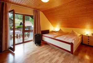 a bedroom with a bed and a large window at Haus Am Kaltenbach in Enzklösterle
