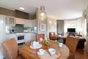 a kitchen and living room with a wooden table and chairs at Villa Apfel in Vale do Lobo