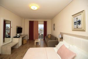 a living room with a bed and a couch at Hotel VD Roleks in Vlorë