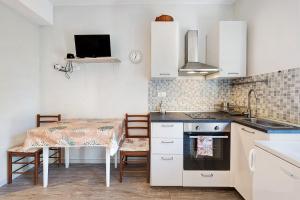 a kitchen with a table and a sink and a stove at Goccia di mare with free parking in Levanto +8 photos