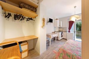 a room with a bed and a desk and a kitchen at Goccia di mare with free parking in Levanto