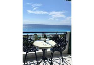 a table and chairs on a balcony with the ocean at Sunset Premium Studio 6 in Lefkada +22 photos