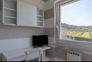 a room with a desk with a monitor and a window at Trilocale colline di Bardolino in Bardolino
