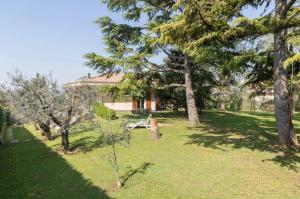 a garden with trees and a house in the background at Trilocale colline di Bardolino in Bardolino