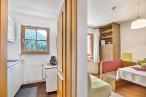 a kitchen and a living room with a table and a window at Appartements Gabrielli Anna in Trodena