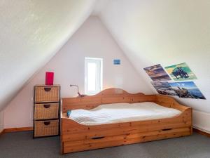 a bedroom with a wooden bed in a attic at Relas Ferienwohnungen - Spatzennest in Nordstrand