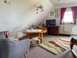 a living room with a table and a tv at Relas Ferienwohnungen - Spatzennest in Nordstrand