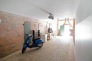 a blue scooter parked next to a brick wall at Ferienwohnung Junge 4 in Lohe-Rickelshof