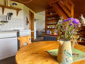 a vase of flowers on a wooden table in a kitchen at Relas Ferienwohnungen - Spatzennest in Nordstrand +25 photos