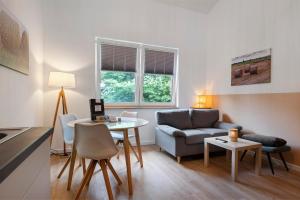 a living room with a couch and a table at Ferienwohnung Junge 4 in Lohe-Rickelshof