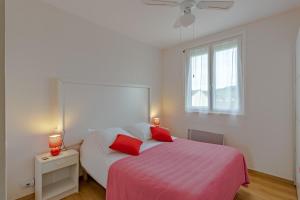 a bedroom with a bed with two red pillows at Lumineux Le Bugue in Le Bugue +22 photos