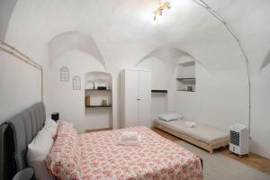 a white room with a bed and a couch at Casetta l'Ulivo in Poggi