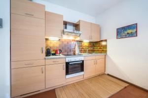 a kitchen with wooden cabinets and a stove at Apartement Oase in Lana