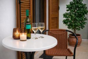 a white table with wine glasses and a bottle of wine at 32sq Apartment with Balcony in Vlachopoulátika