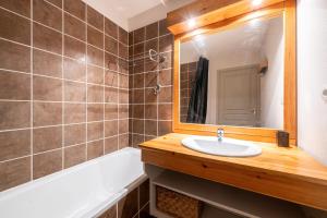 a bathroom with a sink and a mirror and a tub at Appartement Atlas in Albiez-Montrond +18 photos