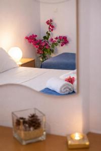 a bedroom with a bed with a mirror and flowers at 32sq Apartment with Balcony in Vlachopoulátika