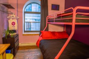 a bedroom with a bunk bed with red pillows at Auberge Alternative in Montreal